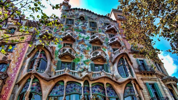 Un bâtiment doté de balcons richement décorés et aux formes courbes, ainsi que de grandes fenêtres.