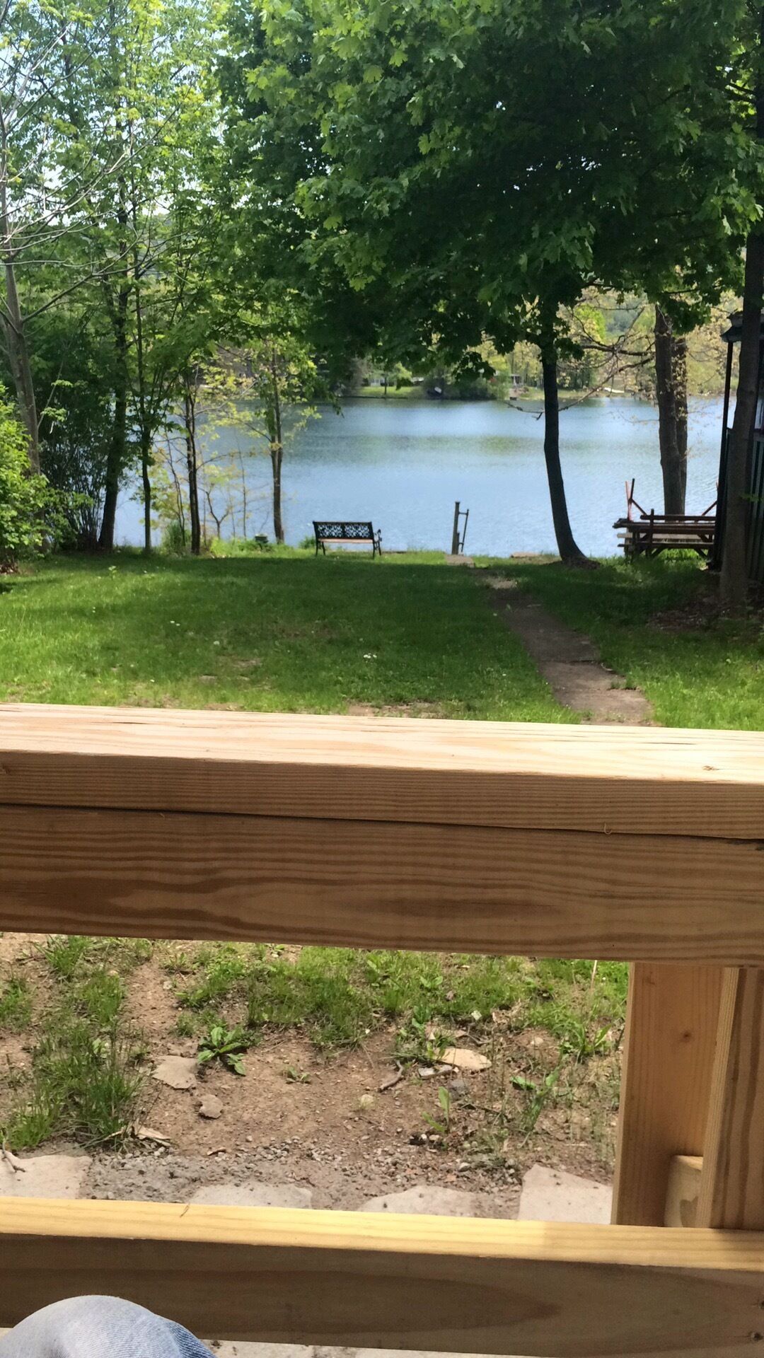Un muelle de madera con vista a un lago, con una banca y una mesa de picnic.