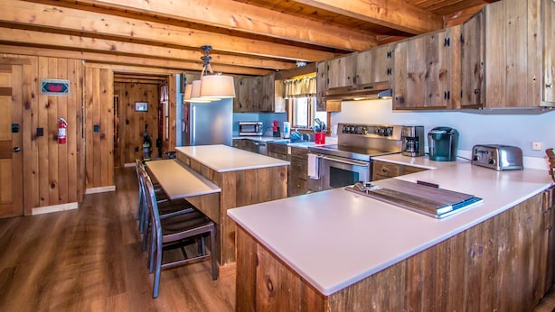 Una cocina con armarios de madera, una isla central y electrodomésticos modernos.