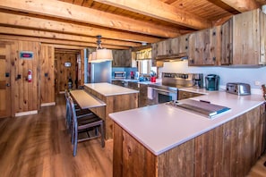 Una cocina con armarios de madera, una isla central y electrodomésticos modernos.
