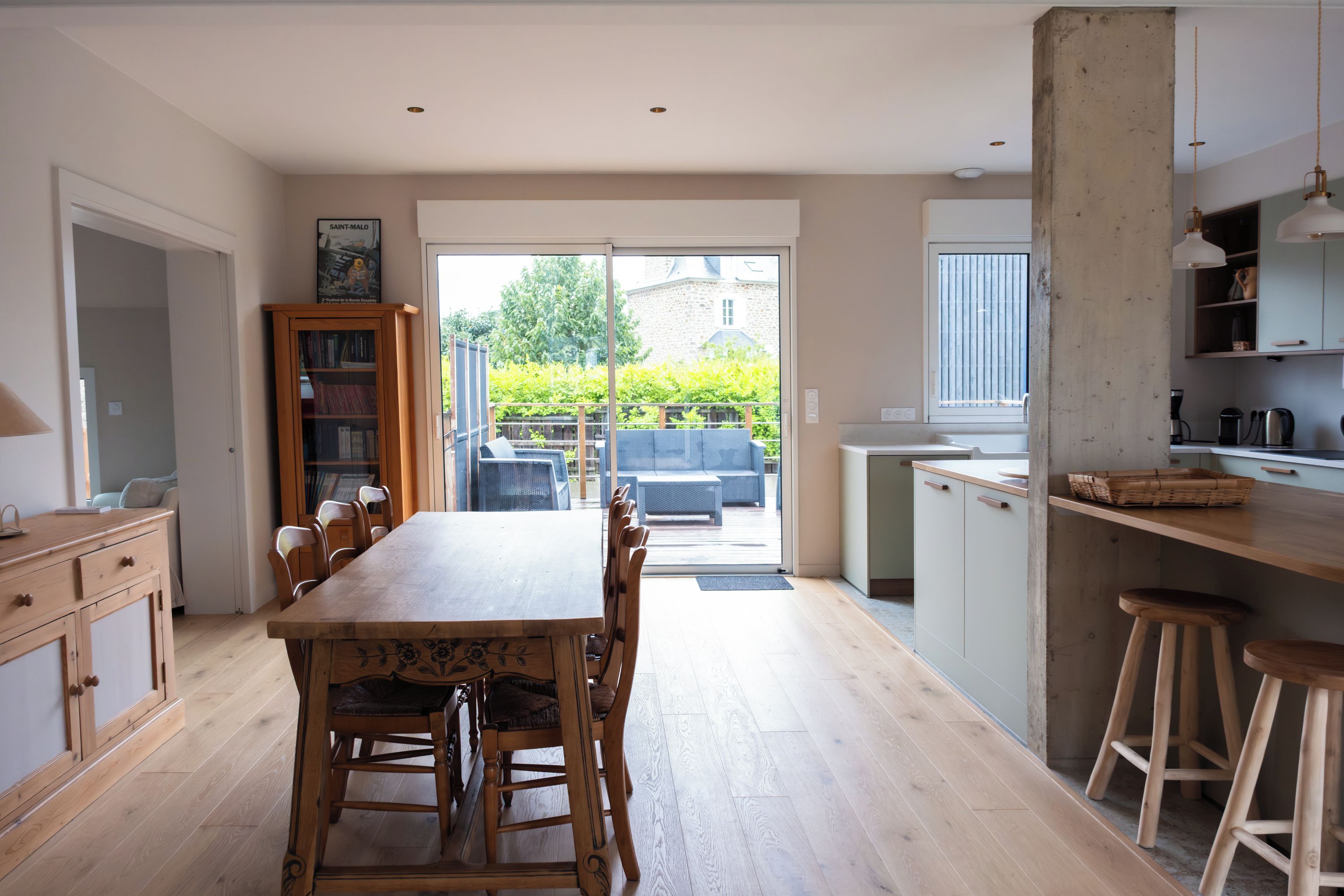 A spacious kitchen with a dining area, wooden cabinets, and a view of the garden.