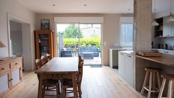 A spacious kitchen with a dining area, wooden cabinets, and a view of the garden.