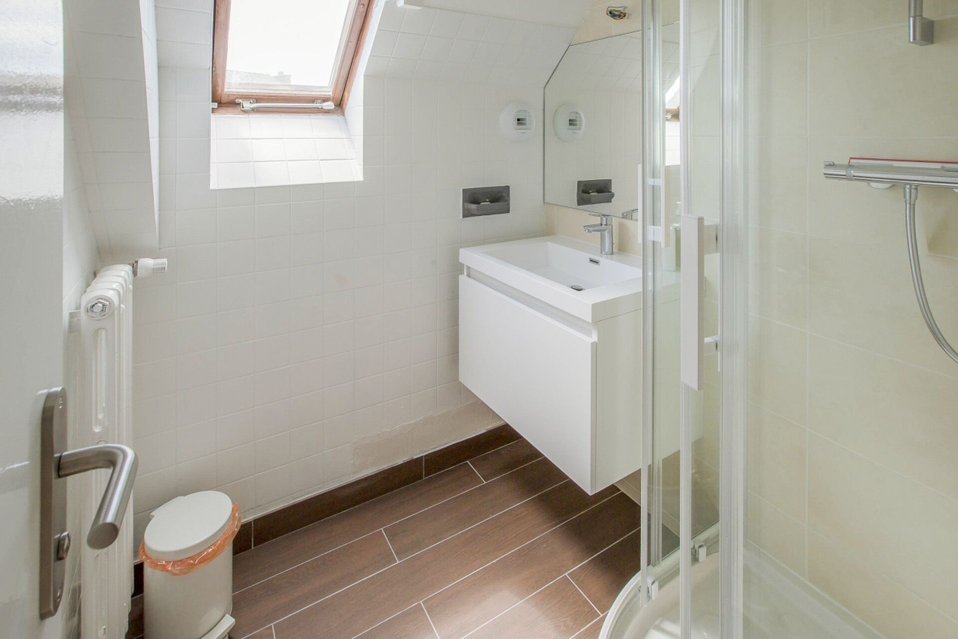 A modern bathroom with a shower, a toilet, and a sink.