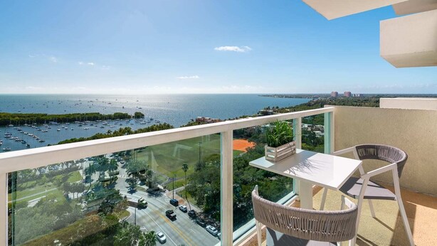 Un balcón con vista a un puerto deportivo y al horizonte urbano.