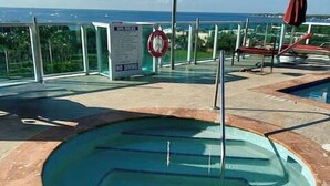 Zona de piscina con cerramiento de vidrio, un flotador salvavidas y un cartel que indica 'No Diving'.