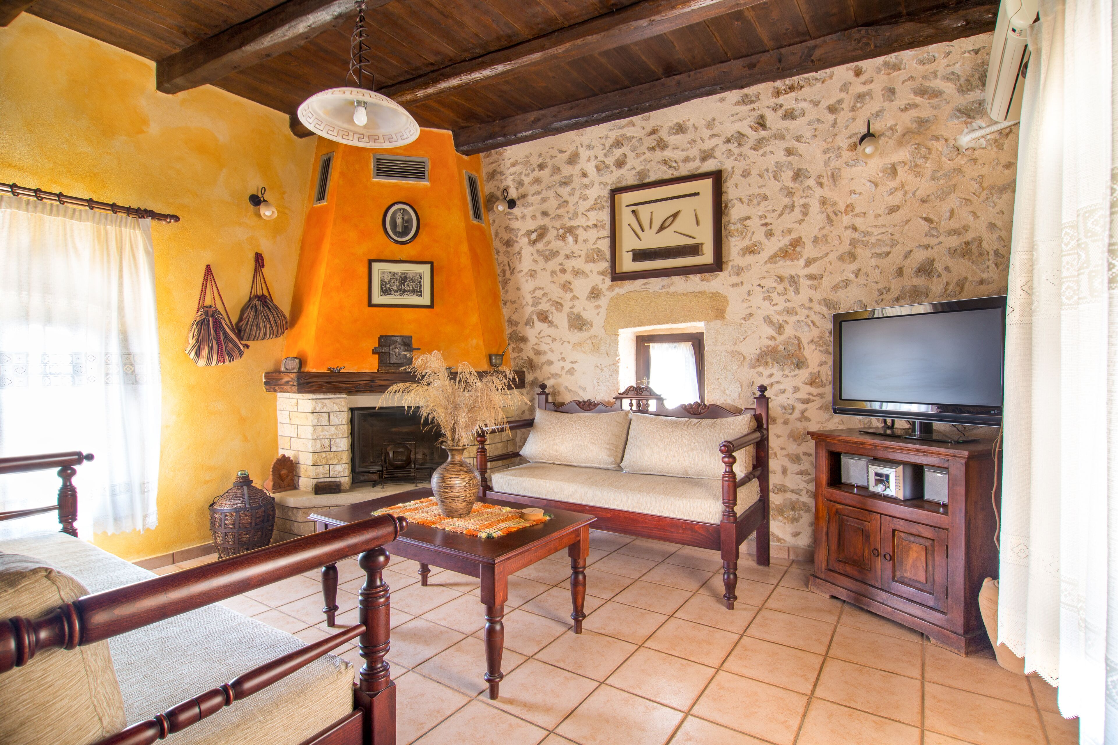 Una sala de estar acogedora con chimenea, un sofá, un televisor y una mesa de centro de madera.