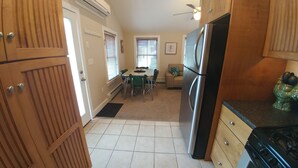 A compact kitchen with a refrigerator, stove, and dining area with chairs and a table. - A short walk everywhere.  Great Fall and Spring Rates (Ogunquit)