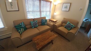A living room with a beige sectional sofa, two wooden coffee tables, and decorative pillows with turtle designs. - A short walk everywhere.  Great Fall and Spring Rates (Ogunquit)
