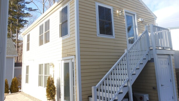 A two-story house with a white exterior, a front door, and a staircase leading to the second floor. - A short walk everywhere.  Great Fall and Spring Rates (Ogunquit)