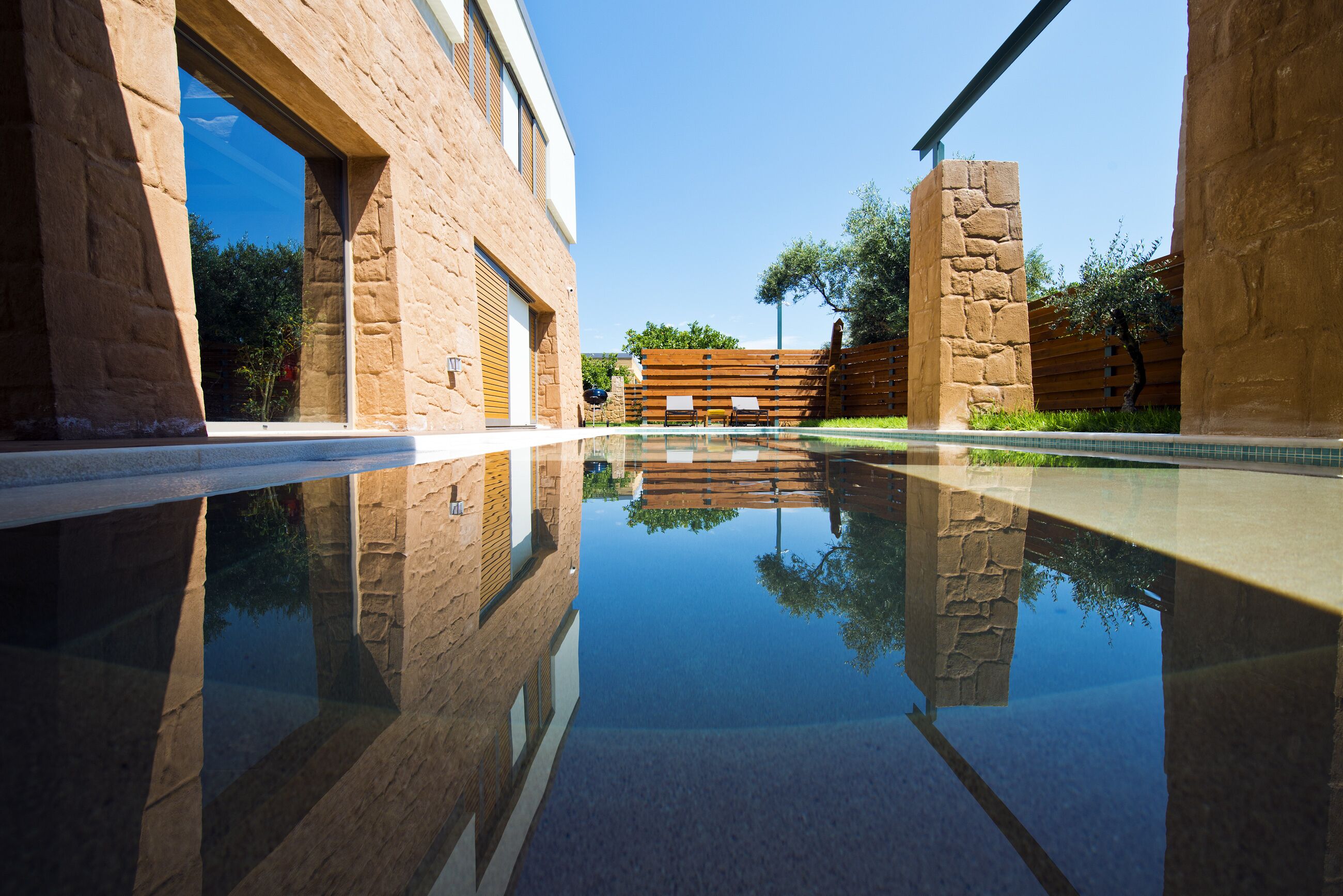 A modern building with a pool reflecting its architecture.