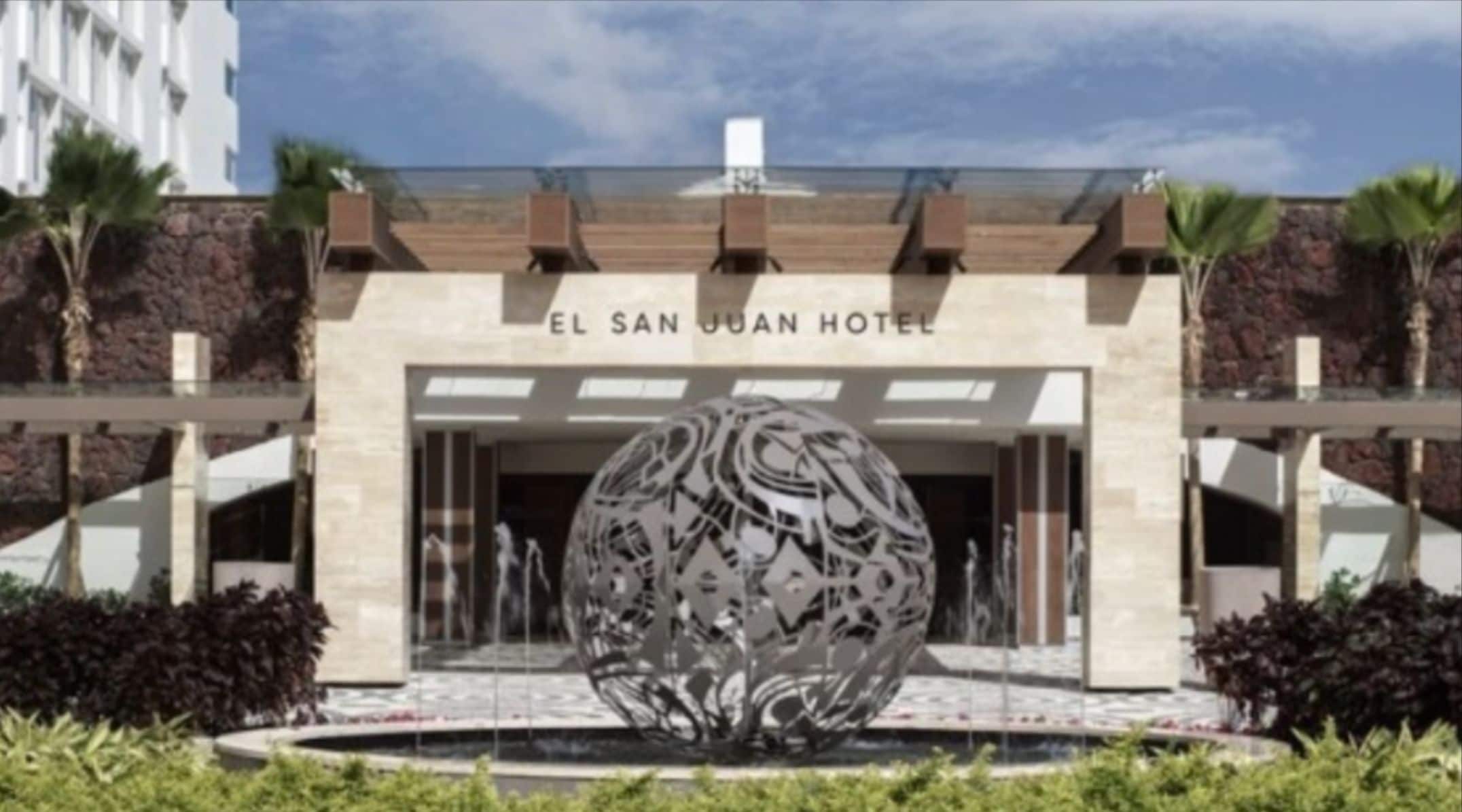 The entrance of El San Juan Hotel with a large decorative sphere in the foreground.