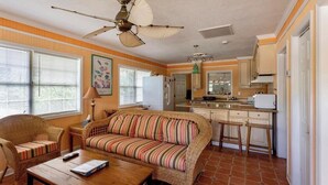 A compact living space with a sofa, coffee table, and a kitchenette area.