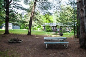 A picnic table in a wooded area with houses in the background. - Hiawatha’s Hideaway Northwoods Cabin Near Pictured Rocks & Area Lakes (Wetmore)