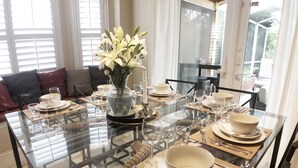 A dining table set for six with clear glassware, plates, and a vase of white flowers. - ☀️ Outstandning & Lavish Luxury Villa ☀️ Private Pool & Spa & Golf Course View ⛳ (Haines City)