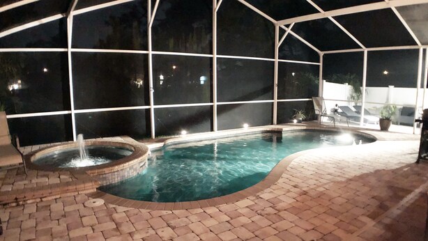 An indoor swimming pool with a brick floor, a hot tub, and lounge chairs. - ☀️ Outstandning & Lavish Luxury Villa ☀️ Private Pool & Spa & Golf Course View ⛳ (Haines City)