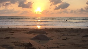 A pair of flip-flops on a sandy beach with the ocean and a sunset in the background. - Amazing Whitewater View Of The Ballena Marine Preserve Islands (Uvita)
