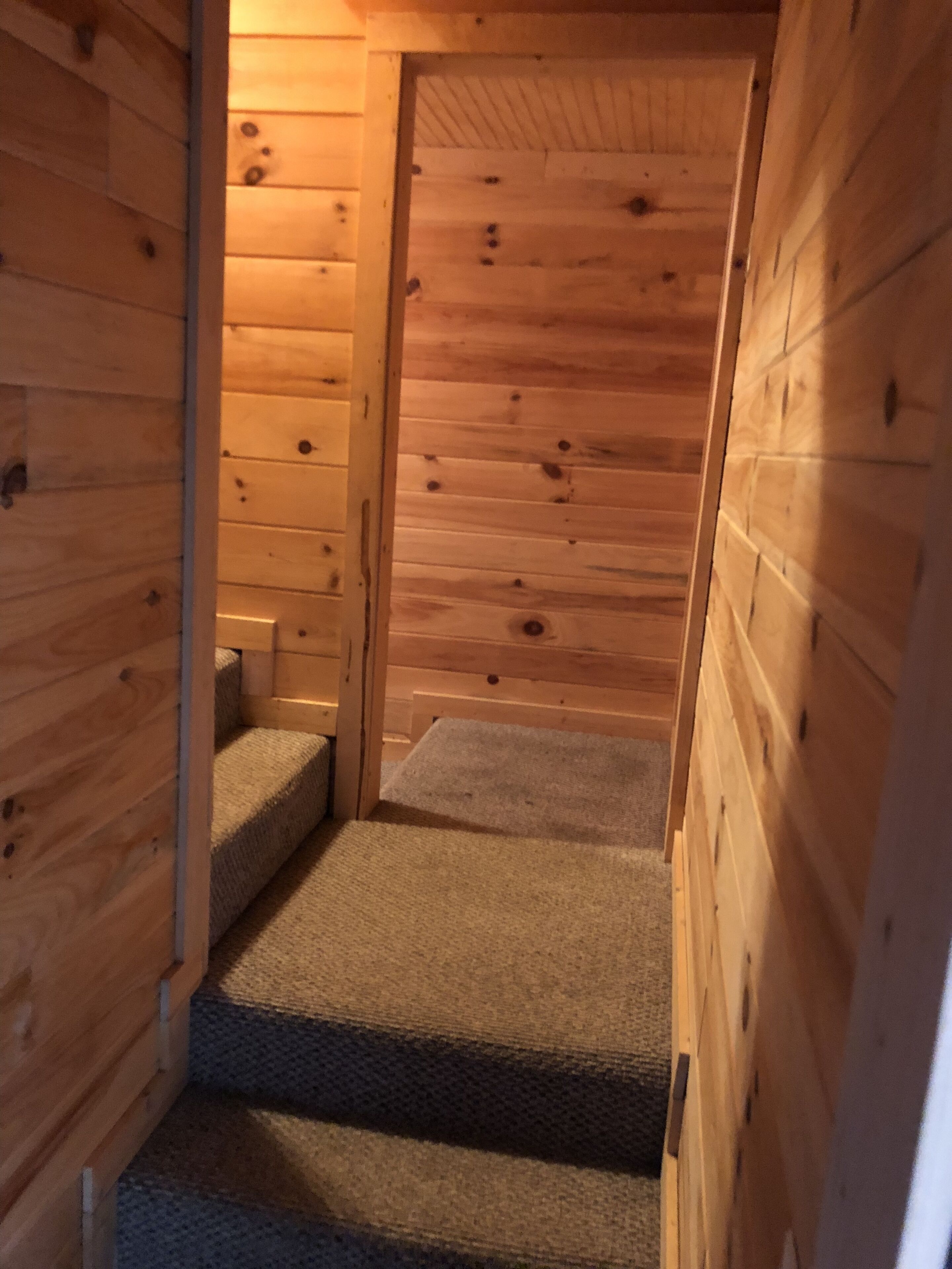 Una scala in legno conduce a un livello superiore in un edificio in stile baita.