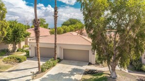 A residential house with a garage, surrounded by palm trees and a well-maintained lawn. - Completely Renovated PGA West - Stadium Course -  Lic #259026 (La Quinta)