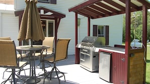 Eine Außenpatio mit Grill und Essbereich.