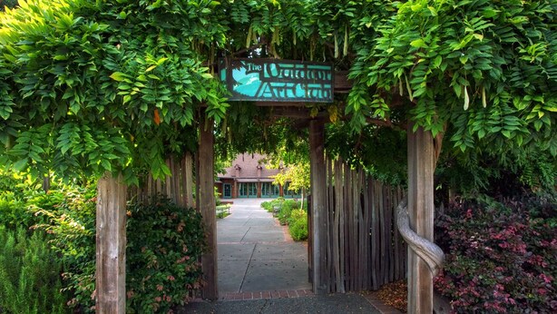 A wooden archway with a sign reading "The Botanical Garden."