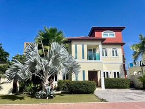 A two-story building with a red roof, beige walls, and blue accents.