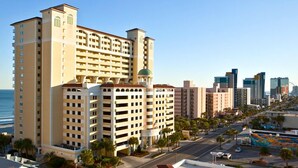 A high-rise hotel with multiple floors, a central courtyard, and a view of the ocean. - 💎NEWLY REMODELED!! ISLAND TIME Honeymoon Suite Direct Oceanfront King Luxury (Myrtle Beach)