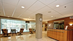 A lobby with a reception desk, seating area, and a large glass wall. - Splendid, Tastful, And Fully Furnished Condo On Lake Travis Island Villa!!! (Lago Vista)