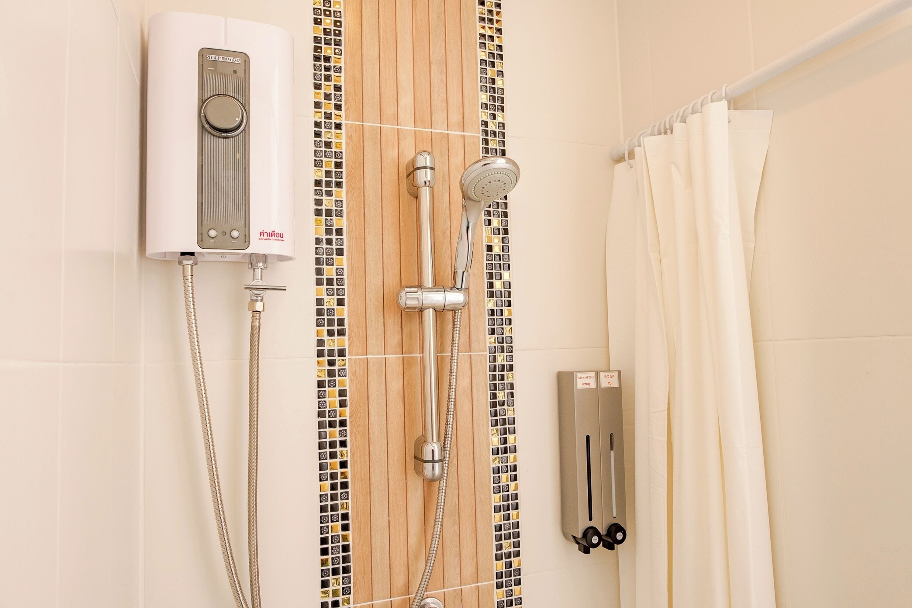 A bathroom with a shower, a wall-mounted heater, and a towel rack.