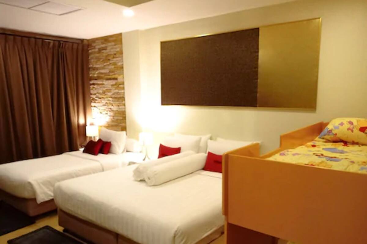 A hotel room with two beds, a large wall-mounted artwork, and a window with curtains.
