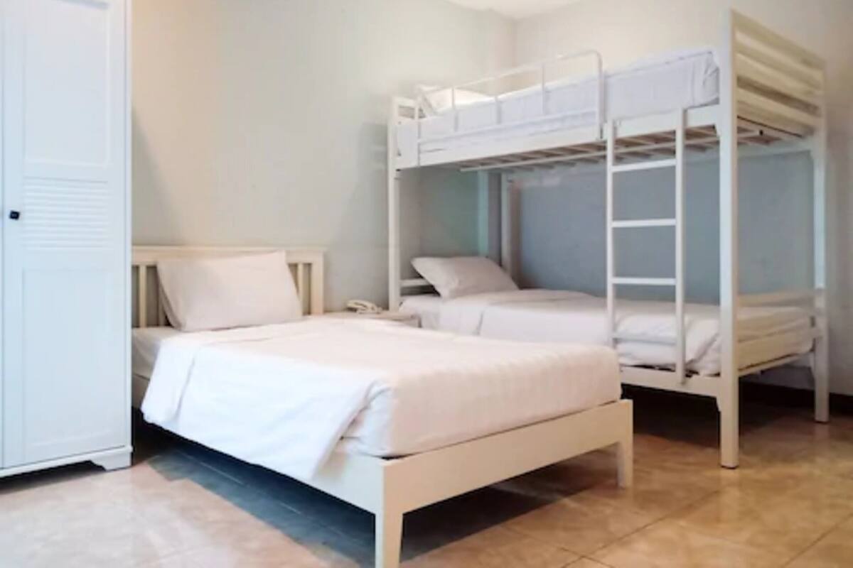 A bunk bed room with a wardrobe and a bedside table.