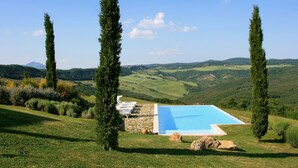 A pool with a view of rolling hills and mountains in the background.