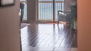 Ein Zimmer mit einer großen Schiebeglas-Tür, die auf einen Balkon mit Meerblick führt.