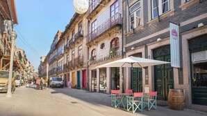 A street with buildings, outdoor seating, and a large decorative sphere. - Flowerstreet54 - Romantic Apartment at Downtown Center (Porto)