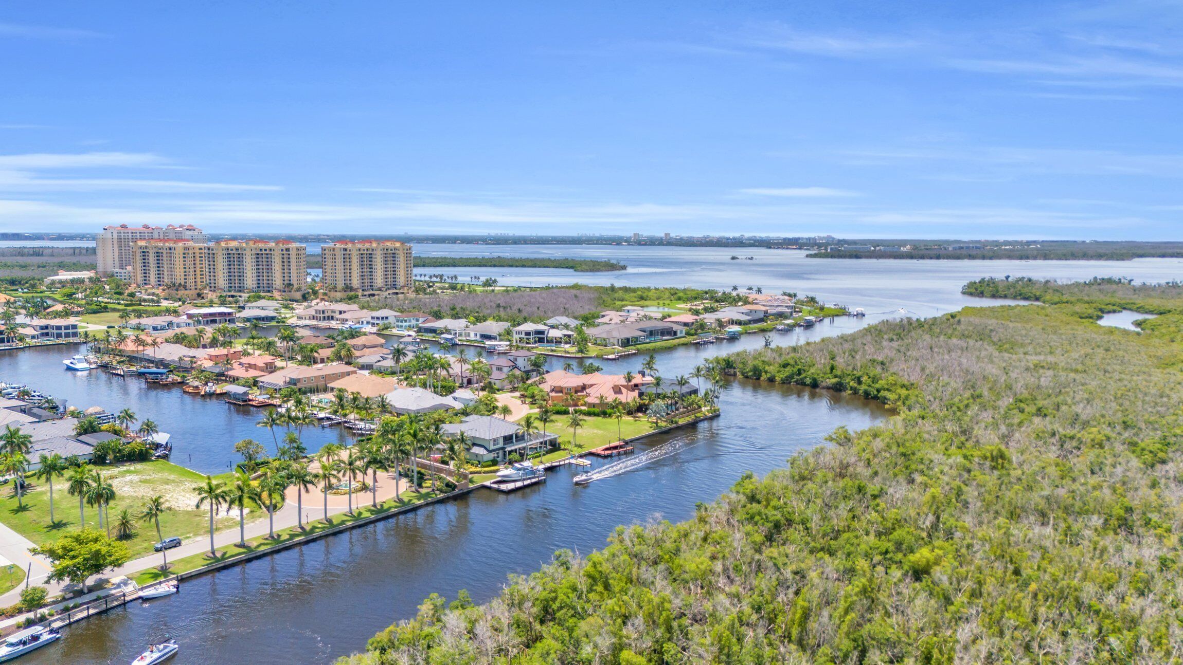 A marina with boats, a golf course, and residential buildings.