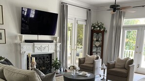 A living room with a fireplace, sofas, a coffee table, and a television. - Spacious Countryside Home Near Sanford - 3BR,2.5BA (Sanford)