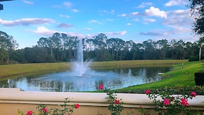 A pond with a fountain, surrounded by a grassy area and trees. - 5*Luxury Villa 6BR,4BA 3Ensuits /Pool facing SE/10mins to Disney parks,free Wifi (Kissimmee)