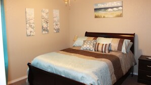 A bedroom with a bed, a nightstand, a ceiling fan, and wall art. - Beautiful & Cozy, BMT Friendly near SeaWorld 3mi/Six Flags 14mi/Lackland 8mi (San Antonio)