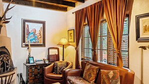 A cozy living room with a leather sofa, a wooden cabinet, and a framed picture on the wall.