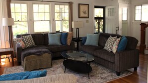 A living room with two sofas, a coffee table, and a patterned rug.