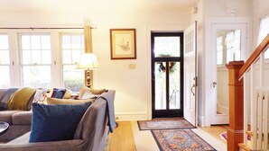 A living room with a sofa, a lamp, and a door leading to another room.