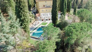 A villa with a swimming pool surrounded by tall trees, a covered outdoor seating area, and a garden. - PRIVATE TUSCAN VILLA WITH HEATED SWIMMING POOL - JACUZZI SPA - SAUNA - EVENTS (chiusi)