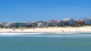 A beachfront property with multiple houses, a sandy beach, and a clear blue sky. - Panoramic Oceanfront home on Emerald Island. Close to everything!! (Emerald Isle)