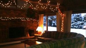 A cozy living room with a fireplace, plaid sofa, and string lights. - Fall Colors Await-Book Early Escape to Crisp Mountain Air-Family Fun Pets ok (Franconia)
