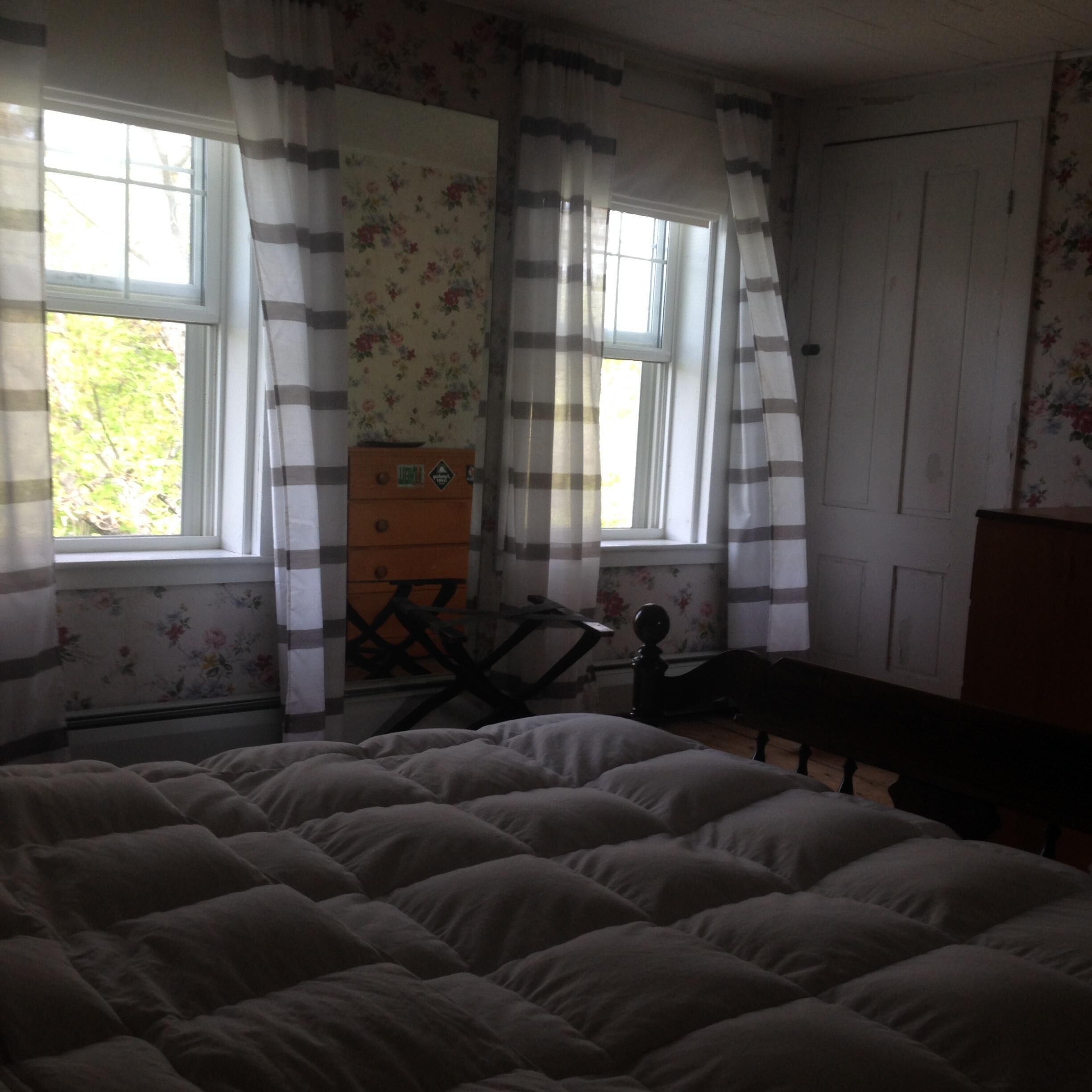 Une chambre à coucher avec un lit, une commode et un bureau.