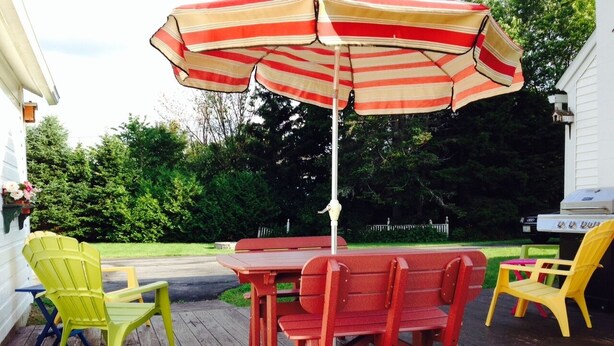 A wooden deck with a picnic table and chairs, an umbrella, and a grill. - Fall Colors Await-Book Early Escape to Crisp Mountain Air-Family Fun Pets ok (Franconia)