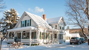 A two-story white house with green shutters, a covered porch, and a snow-covered roof. - Fall Colors Await-Book Early Escape to Crisp Mountain Air-Family Fun Pets ok (Franconia)