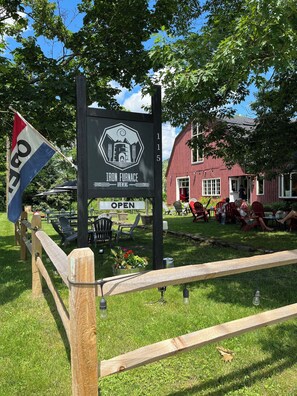 An outdoor seating area with a sign for Iron Furnace Brewing.