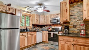A kitchen with wooden cabinets, a stainless steel refrigerator, a microwave, an oven, and a coffee maker. - Camelback,Aquatopia/Camelbeach Waterparks,Pool,Tennis,Paintball,Zip-Line,Jacuzzi (Tannersville)