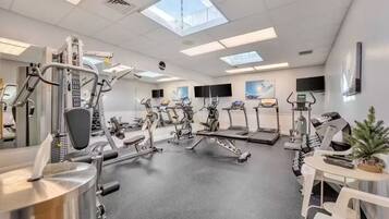 A gym with various exercise equipment, including treadmills, stationary bikes, and weight machines.