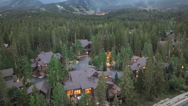 A mountainous area with multiple houses surrounded by dense forests.